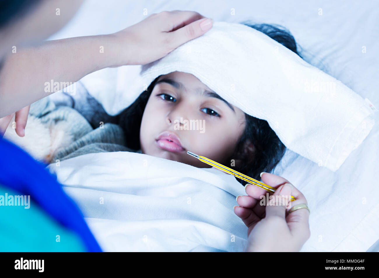Krankes Mädchen Lying-Bed Mutter Kontrolle Temperatur mit dem Thermometer, High-Fever zu Hause Stockfoto