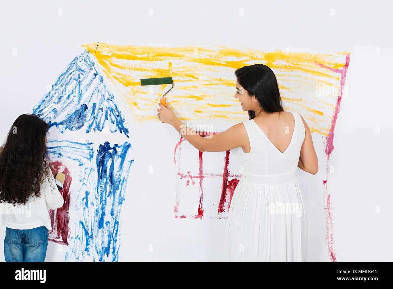 Zwei Mutter und Tochter renovieren Home Mädchen Malerei Haus an der Wand Stockfoto