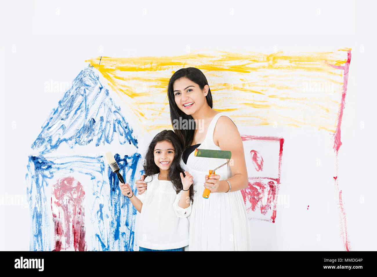Glückliche Mutter und Kind Tochter mit Pinsel macht Reparaturen zu Hause Stockfoto