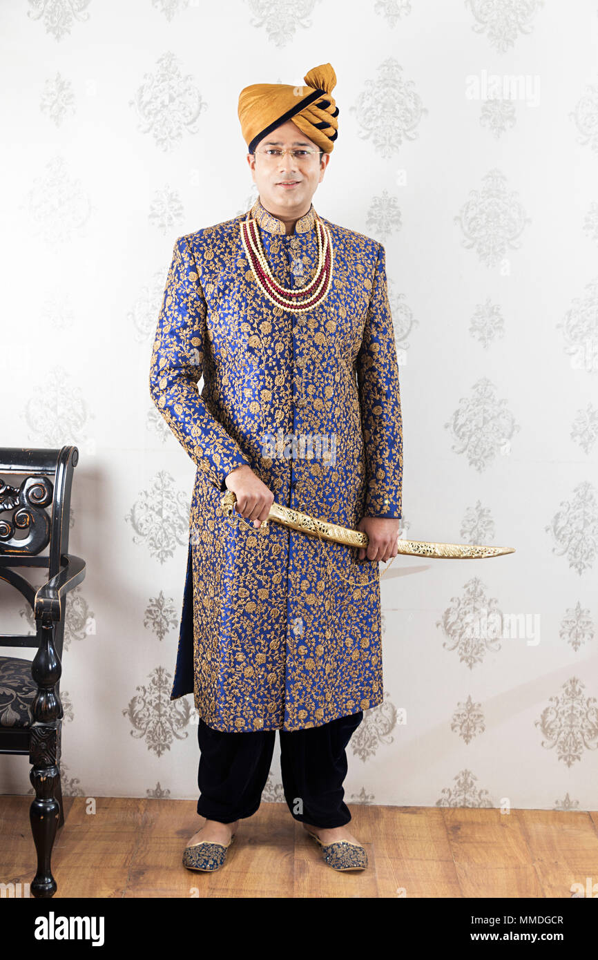 Traditionelle indische Royal mann Rajput neueste shewani mit Schwert tragen Stockfoto