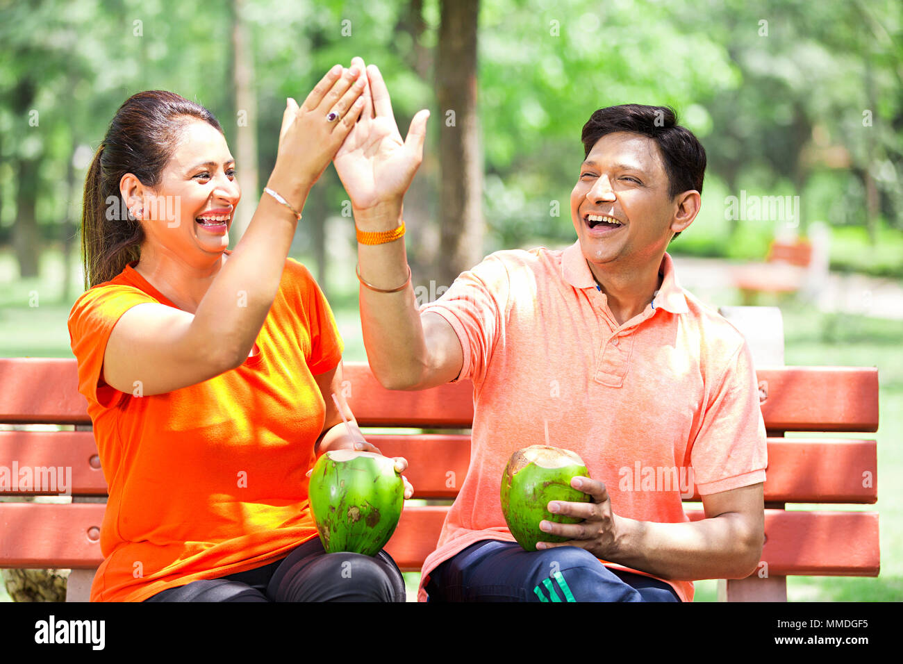 Mann Frau Paar trinken Kokosmilch Händeklatschen Spaß fröhliche Garten Stockfoto