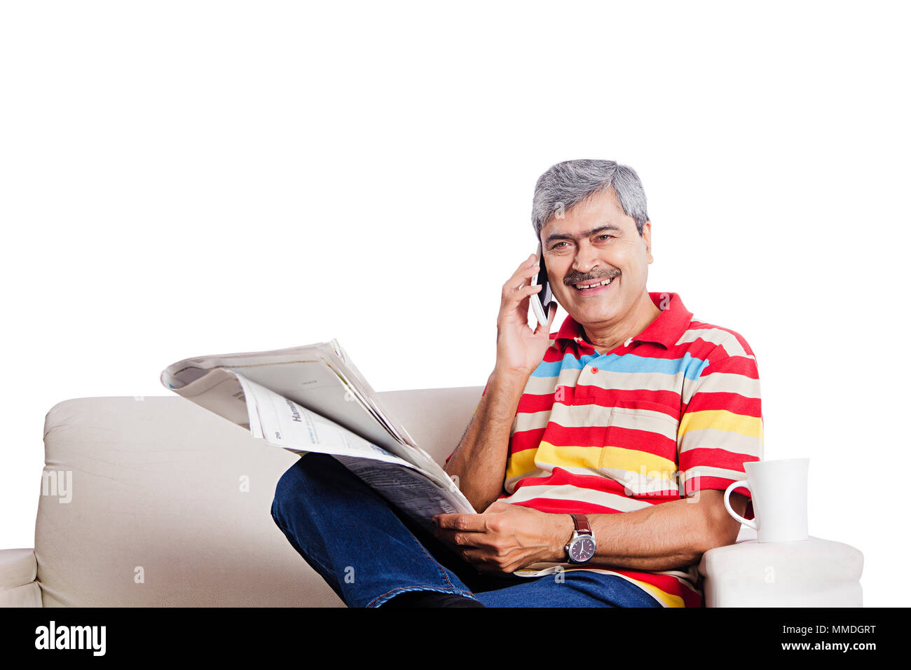 Ein älterer Mann sitzen Sofa lesen Zeitung und Sprechen Cellphone Vor-Ort-Service Stockfoto