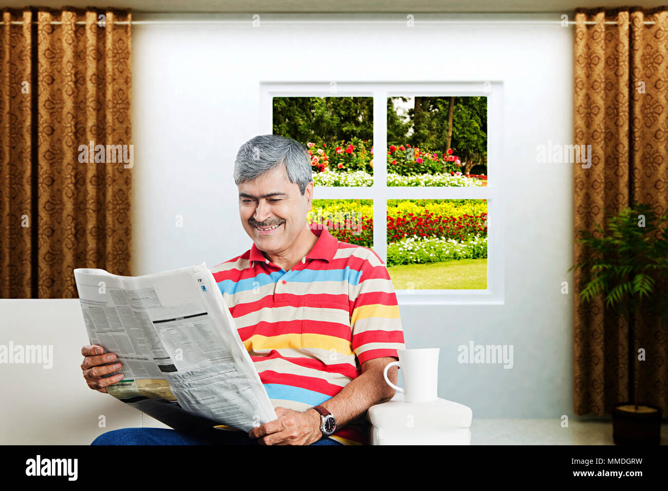 Ein älterer Mann, Sofa lesen Zeitung Morning News Vor-Ort-Service Stockfoto