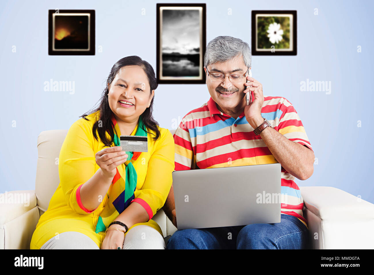 Älteres Ehepaar miteinander reden Handy online shopp. Laptop und Debit-card.at-home Stockfoto