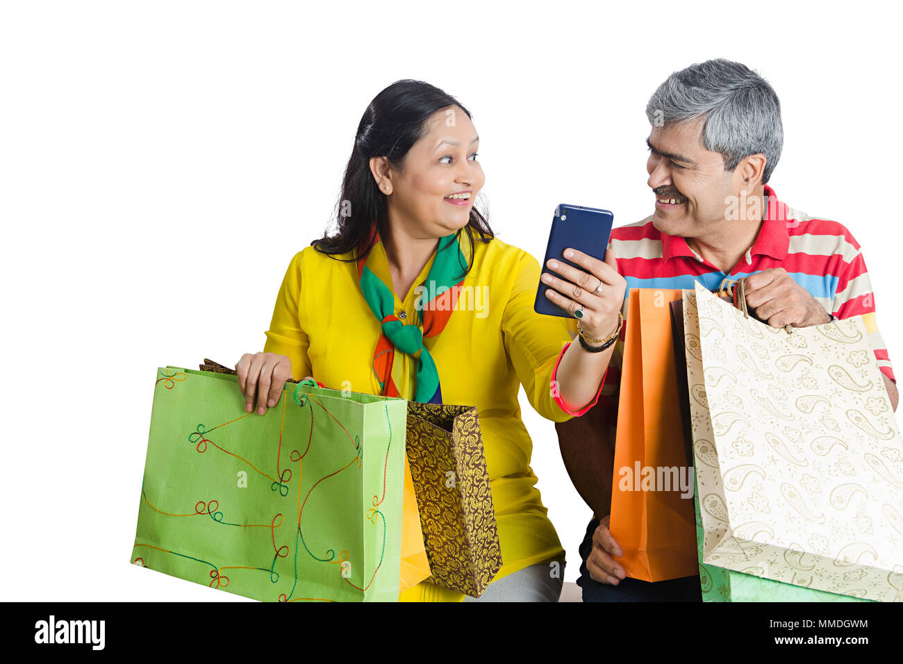 Lächelnd zwei Paar mit Einkaufstaschen lesen Text-Message auf Mobile-Phone Stockfoto