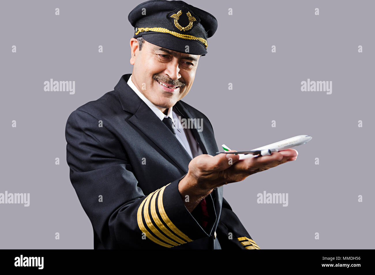 Ein alter Mann Airline Pilot mit Spielzeug Air-Flugzeug auf seinem Hand-Palm Stockfoto