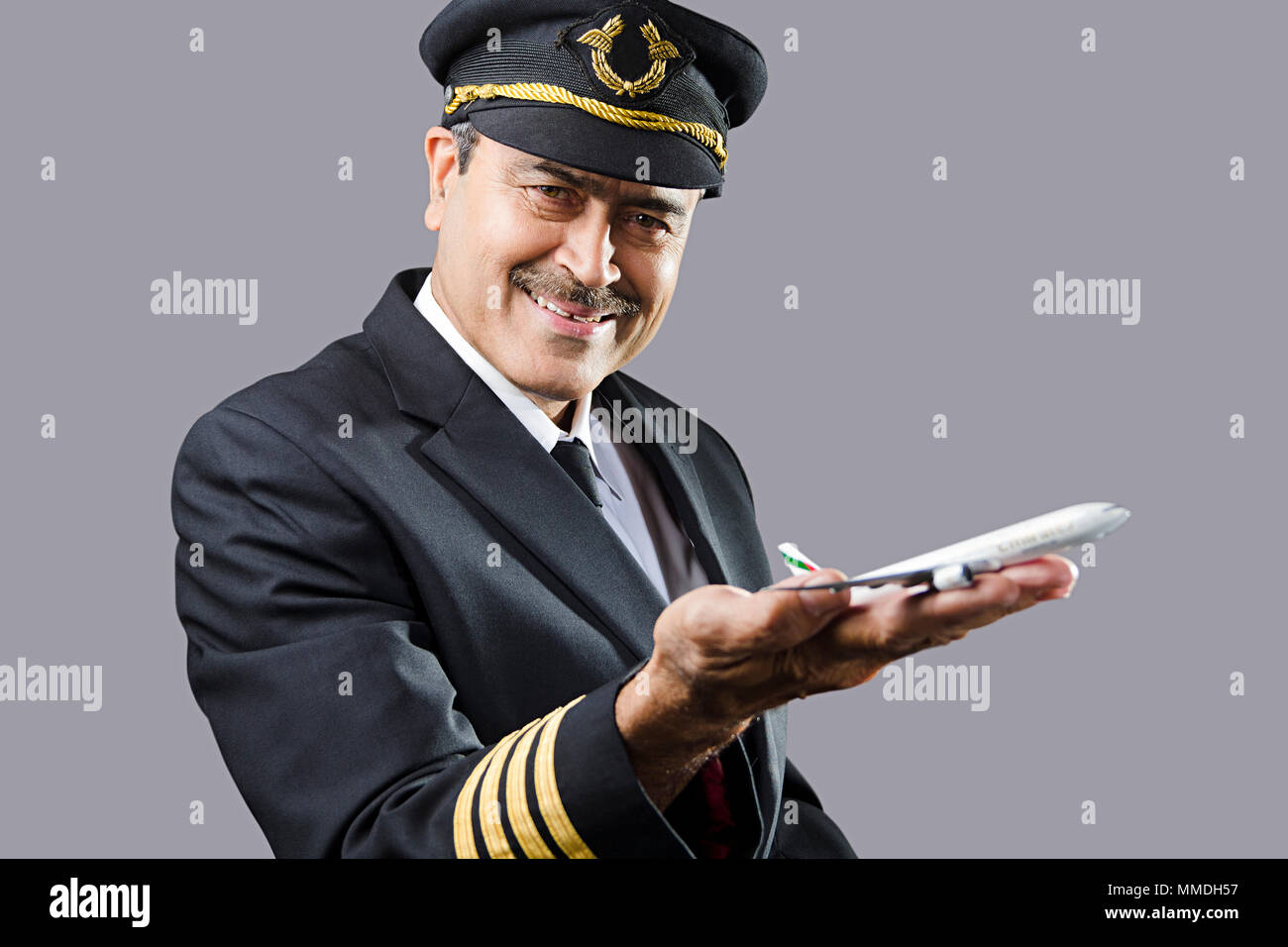 Ein älterer Mann Pilot mit Spielzeug Air-Flugzeug auf seinem Hand-Palm Stockfoto