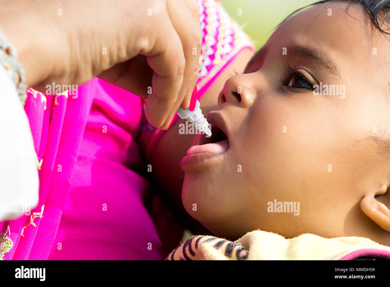 Nahaufnahme Indischen ländlichen Mutter Kind mit Arzt Polio-Drop Medizin Stockfoto