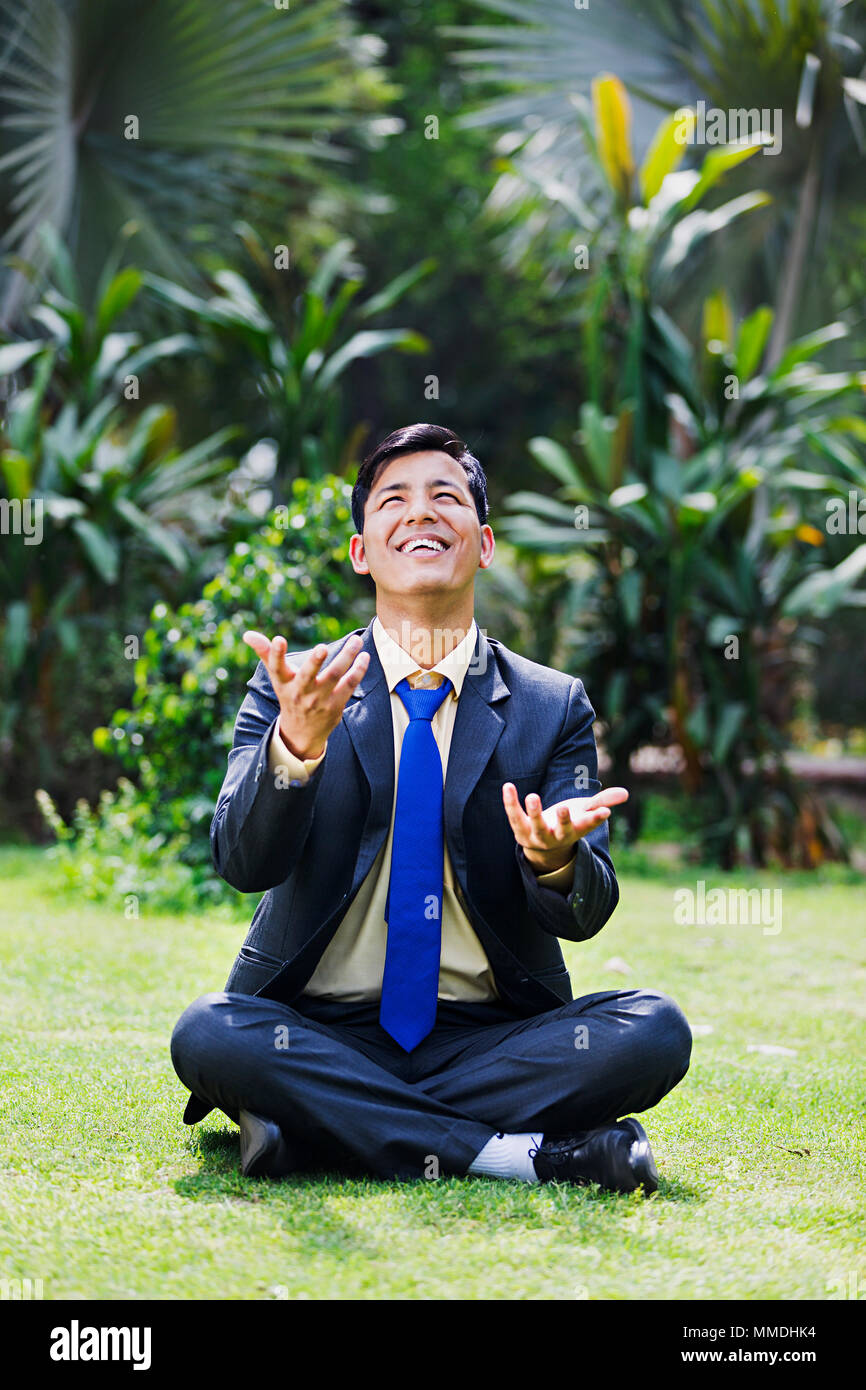 Ein Mann sitzt Gras Spielen jonglieren Genießen Fang In-Garden Stockfoto