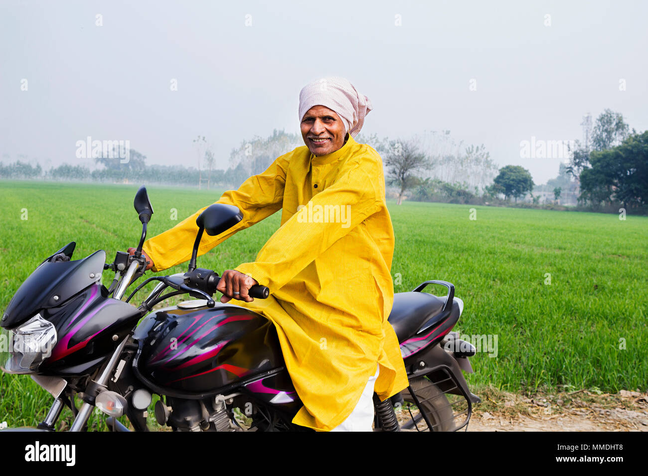 Eine ländliche Dorfbewohner älterer Mann reitet ein Motorrad In-Farm Dorf Stockfoto