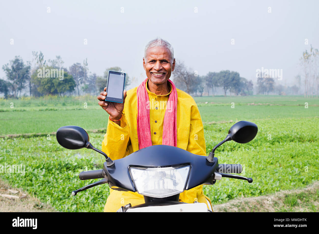 Ein Dorfbewohner älterer Mann, Roller, Cellphone Feld Dorf Stockfoto