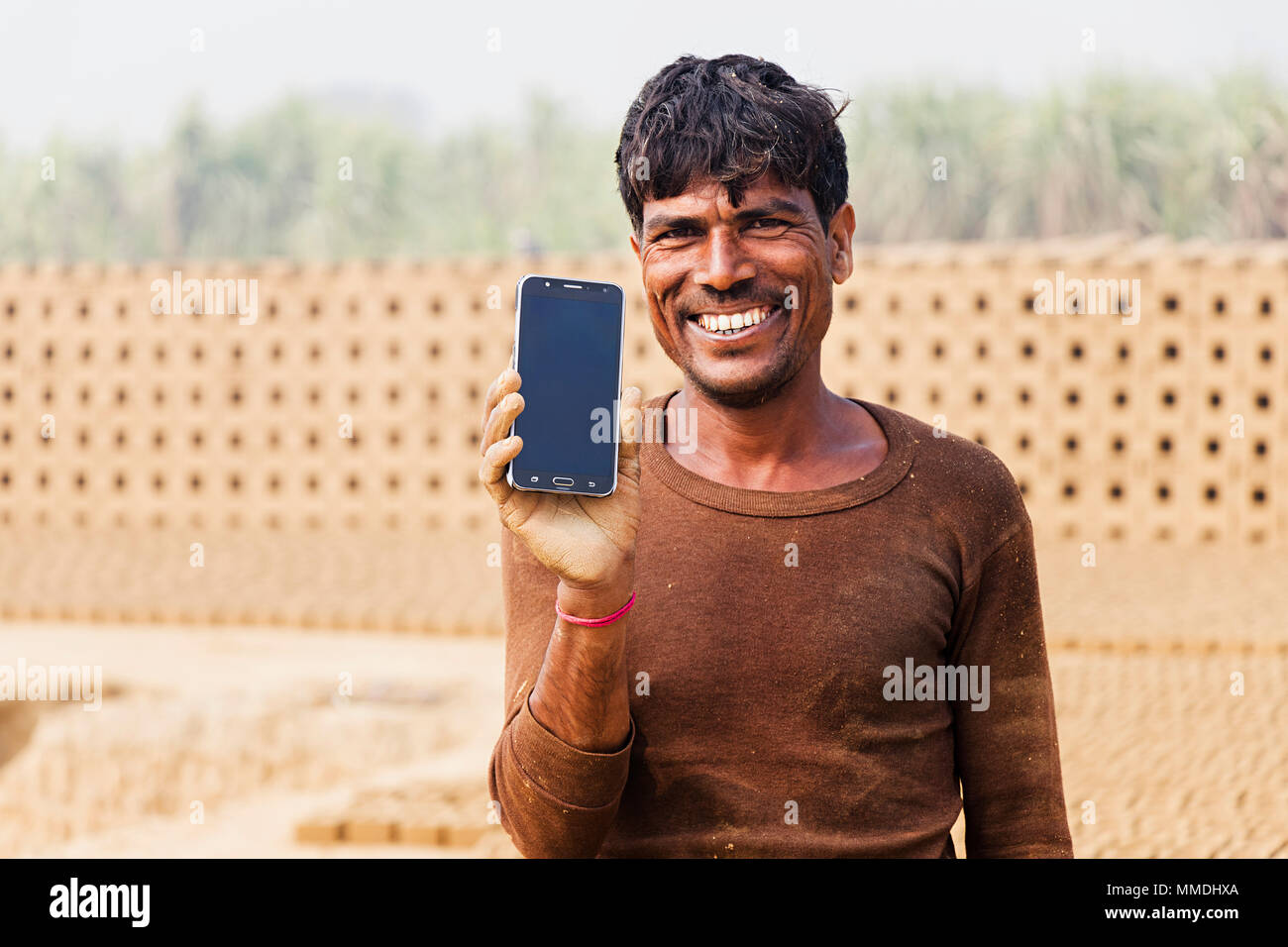 Eine Arbeiterin Mann zeigt Smart Phone In Dorf Ziegelfabrik Stockfoto