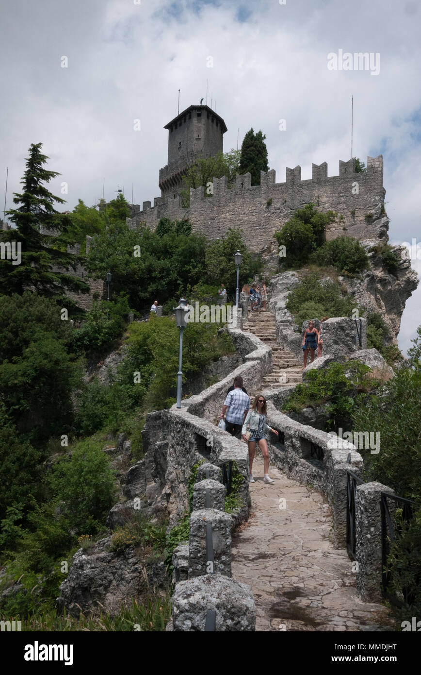 Touristen gehen um die zinne Wände in der Nähe von Guaita - eines der drei Türme von San Marino. Stockfoto