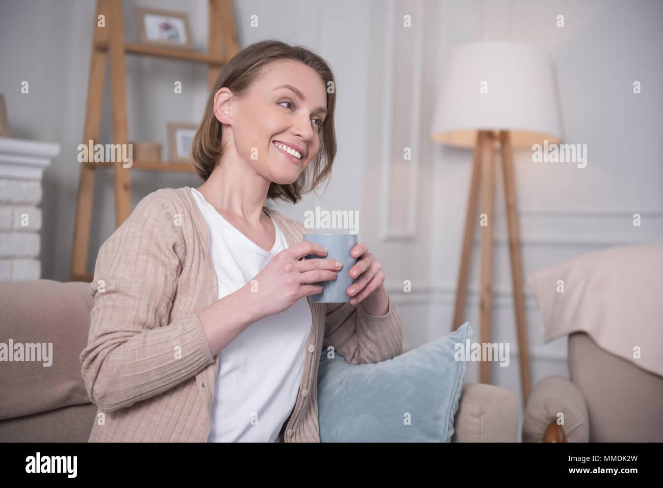 Gerne Frau trinkt Tee zu Hause. Stockfoto