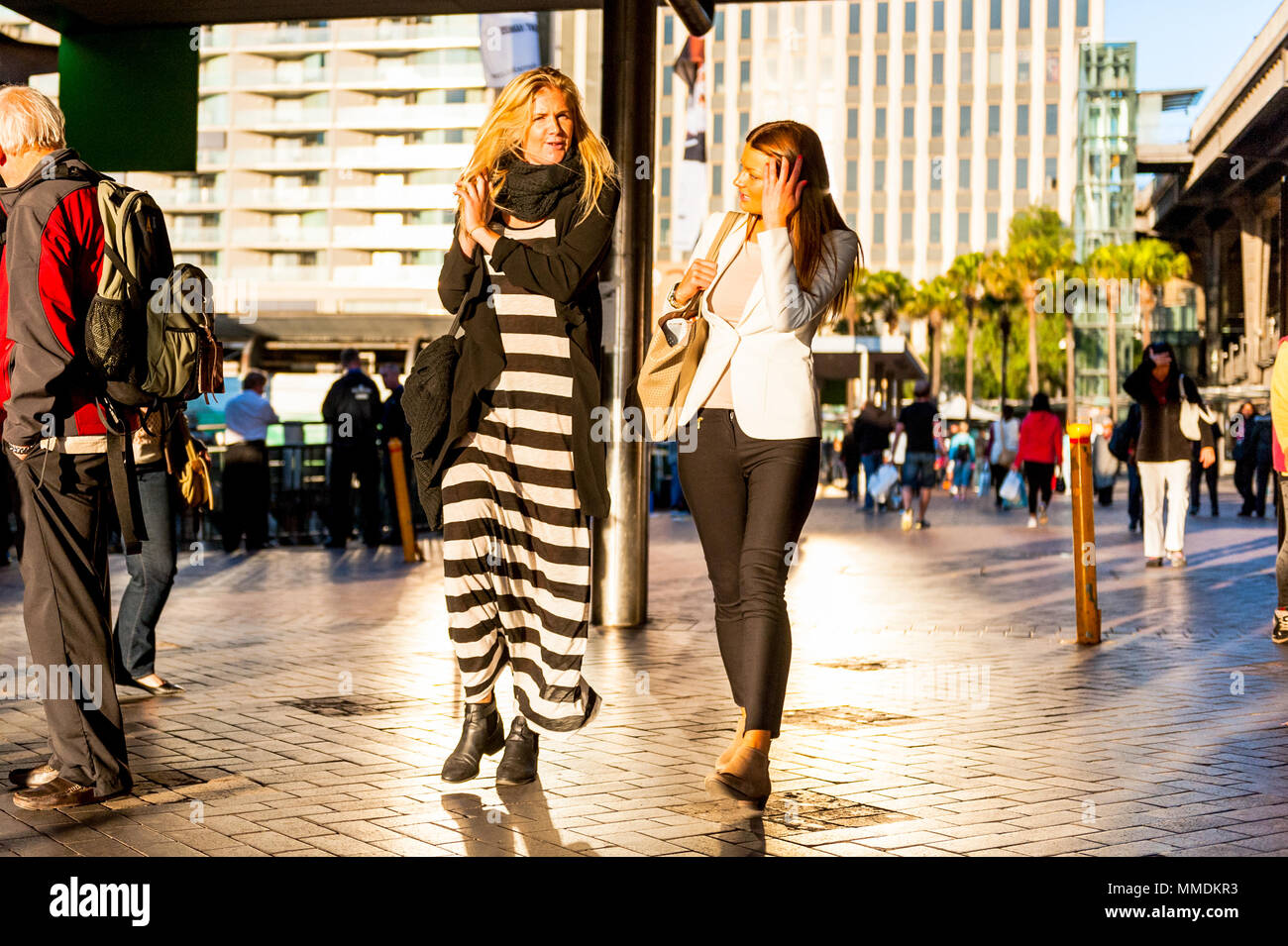 Menschen kommen und gehen in einem langen, sonnigen Nachmittag am Fährterminal im Hafen von Sydney in Australien. Stockfoto