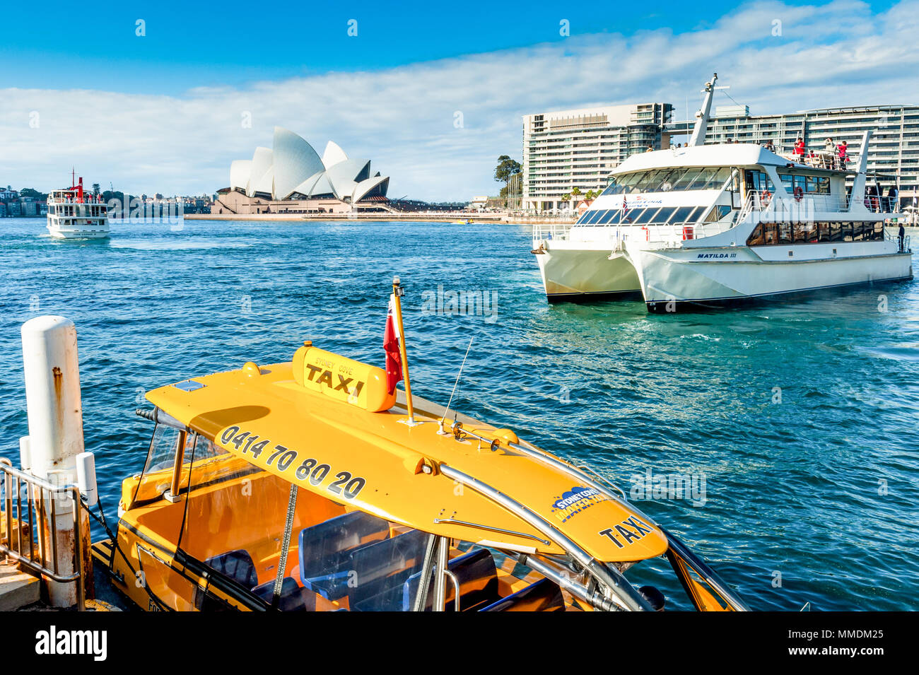 Fähre anreisen am Sydney Australien Ferry Terminal auf einem warmen Sommern Nachmittag mit Touristen genießen das Wetter. Ein taxiboot liegt in der Nähe günstig durch. Stockfoto