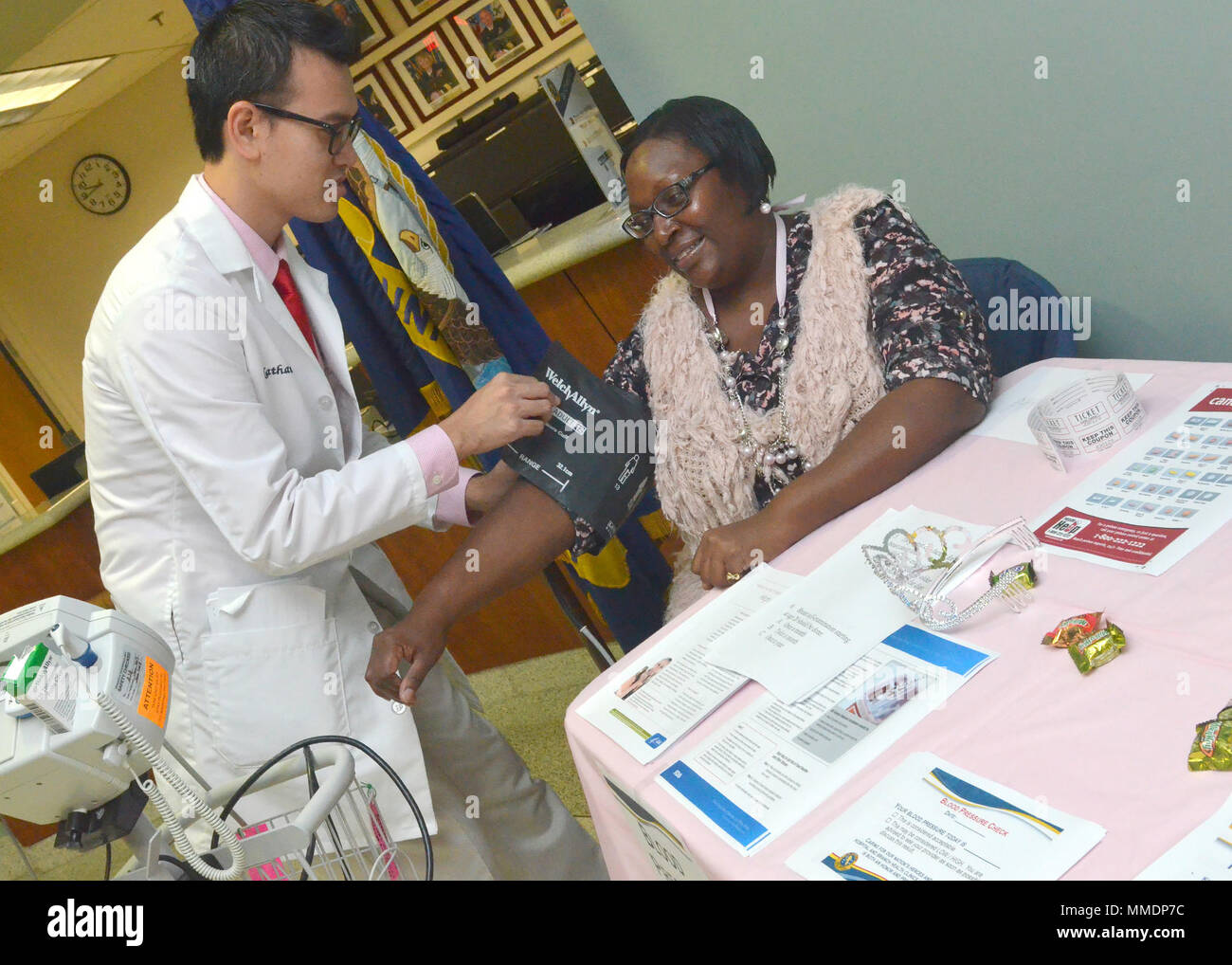 JACKSONVILLE, Fla. (Okt. 2010) 18, 2017) - Nathan Pham, ein Apotheker, der intern von der Universität von Florida, Schecks Bertina Ingram Blutdruck während einer Apotheke Woche Veranstaltung in Naval Hospital Jacksonville am 11.10.18. Hoher Blutdruck ist ein direkter Beitrag zur Herzkrankheit. Viele Menschen haben keine Anzeichen oder Symptome auf, sind aber immer noch in Gefahr. Risikofaktoren sind eine Familiengeschichte (hoher Blutdruck), Rauchen, Diabetes, hohes Cholesterin, oder Übergewicht. Übung, essen mehr Obst und Gemüse und die Senkung von Salz kann helfen, aber manchmal Medikation erforderlich ist. Sprechen Sie mit Ihrem primären Stockfoto