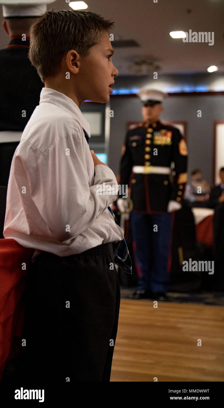 Ein Kind steht mit seiner Hand über sein Herz für die Nationalhymne während der Eröffnungsfeier der 7. jährlichen Mini Marine Corps und Marine Kugel an der Marine Corps Air Station Iwakuni, Japan, Okt. 21, 2017. Die Mini Ball erlaubt Kinder Service Members' die Feier der beiden Dienste "Geburtstag zu erleben, und bot einen Einblick in die Geschichte, die dahinter steht. (U.S. Marine Corps Foto von Cpl. Donato Maffin) Stockfoto