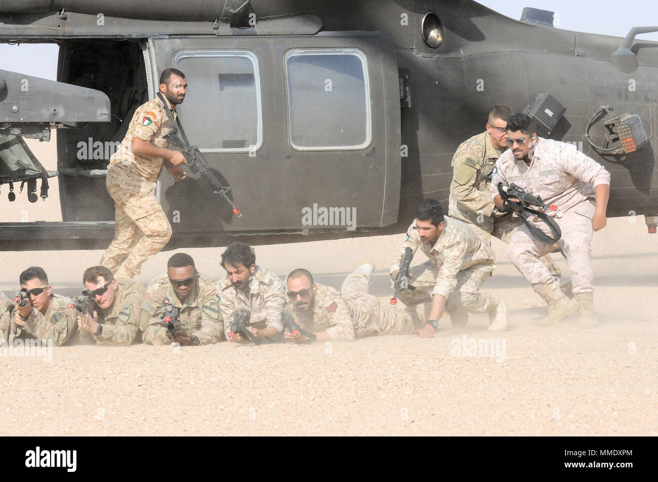 UDARI, Kuwait - USA und kuwaitische Kräfte schnell in Position bringen, da sie die Ausfahrt UH-60M Black Hawk Hubschrauber während heiße Ladung Training mit 1-147 Assault Helicopter Bataillon, Task Force Wraith, 29 Combat Aviation Brigade, und Soldaten der 3. Brigade Combat Team, 1.Kavallerie Division in Vorbereitung auf die Übung Wüste Wand in Urdari, Kuwait, der 4. Oktober 2017. Wüste Wand bestand aus Luft- und bodenoffensive Ausbildung und getestet, um die Interoperabilität der Kuwait Soldaten mit ihren US-amerikanischen Pendants. (Foto von der U.S. Army Staff Sgt. Isolda Reyes) Stockfoto