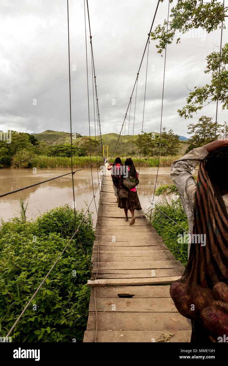 Wamena, Indonesien. Drei lokale Dani Frauen tragen die Last über die Brücke, Papua Neu Guinea. Stockfoto