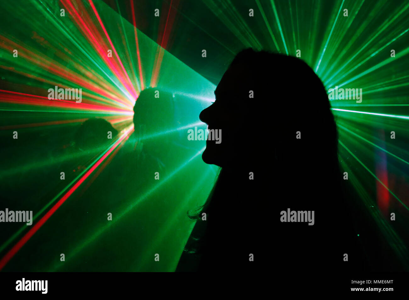 Silhouette einer Gruppe von Menschen tanzen in einer Disco mit Laser. Stockfoto