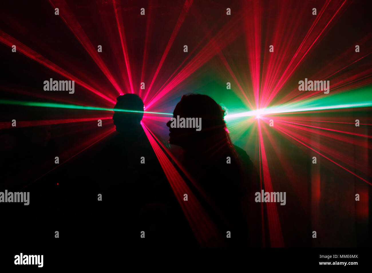 Silhouette einer Gruppe von Menschen tanzen in einer Disco mit Laser. Stockfoto