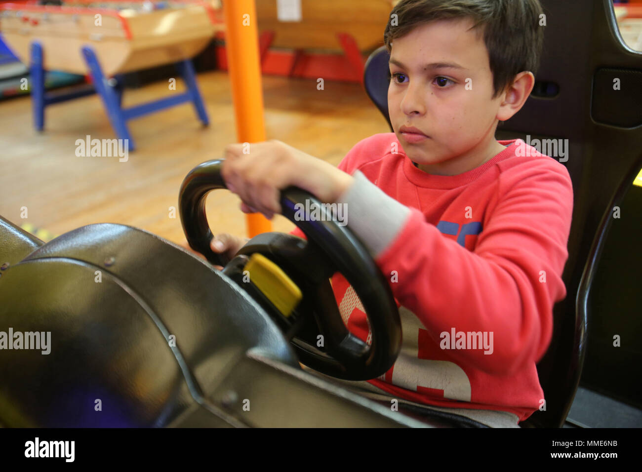 Der 11-jährige Junge spielt in einem Spiel Salon. Cabourg, Frankreich. Stockfoto