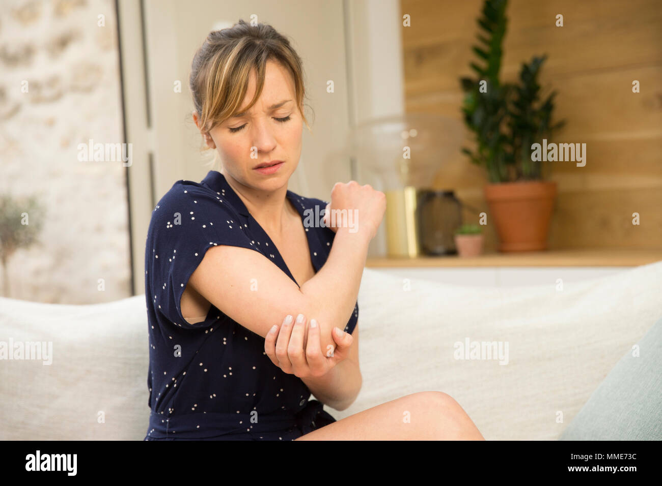 FRAU MIT SCHMERZHAFTEN ELLENBOGEN Stockfoto