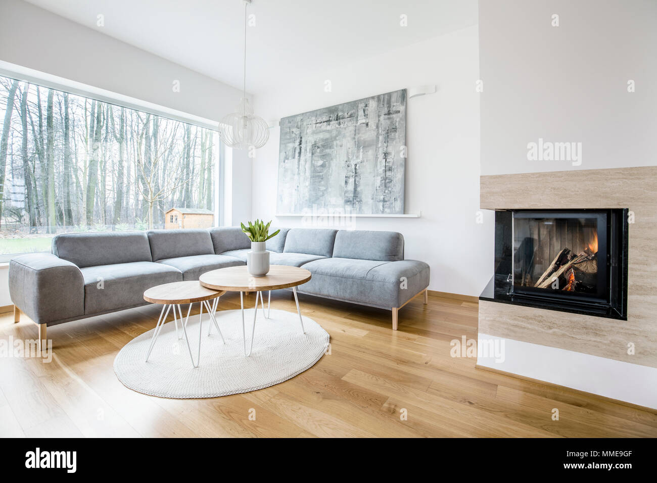 Holz Tabelle Auf Einem Runden Teppich In Der Nahe Von Sofa In Ein Geraumiges Wohnzimmer Mit Kamin Und Malerei Stockfotografie Alamy