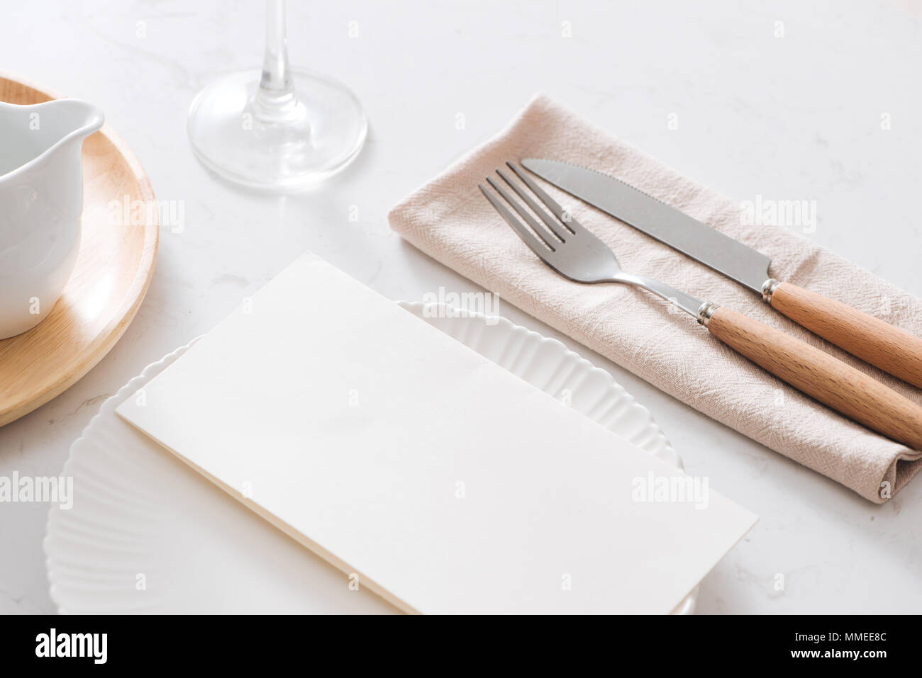 Tischdekoration. Weiße Platten, Gabel, Messer am grauen Stein Platte Stockfoto