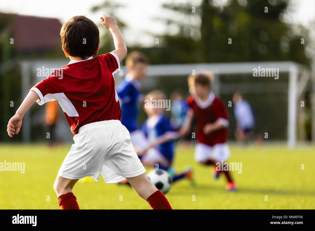 Kinder spielen Fußball Match. Training Fußball-Spiel zwischen Jugend Fußball-Teams. Kinder Soccer Academy Spieler kicken Fußball an einem sonnigen Tag Stockfoto