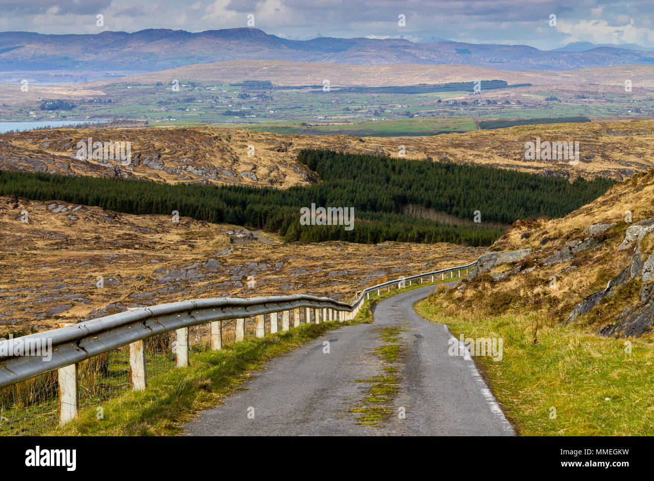 Die Straße hinunter vom Berg Gabriel in Irland mit Blick über die Irische Landschaft und schneebedeckten Gipfeln in der Ferne. Stockfoto