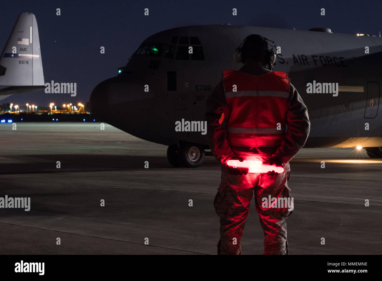 Papst Army Airfield, N.C. - Staff Sgt. Luis De La Cruz, eine C-17 und C-130 aircraft Maintenance Technician in 43 d Air Mobility Squadron hier, wartet auf eine C-130J Hercules mit fallschirmjäger von der 82nd Airborne Division der Armee geladen während der Nacht auf der Grünen Rampe hier Okt. 26 Marschall. Das Flugzeug und die Crew vom 317. Airlift Wing an Dyess Air Force Base, Texas, flog Missionen von Papst Feld alle Woche mit Unterstützung vom 43 d Air Mobility Operations Gruppe hier, die Bereitschaft der Flieger und Soldaten Unterstützung Amerikas globale Response Force. (U.S. Air Force Foto/Marc Barnes) Stockfoto