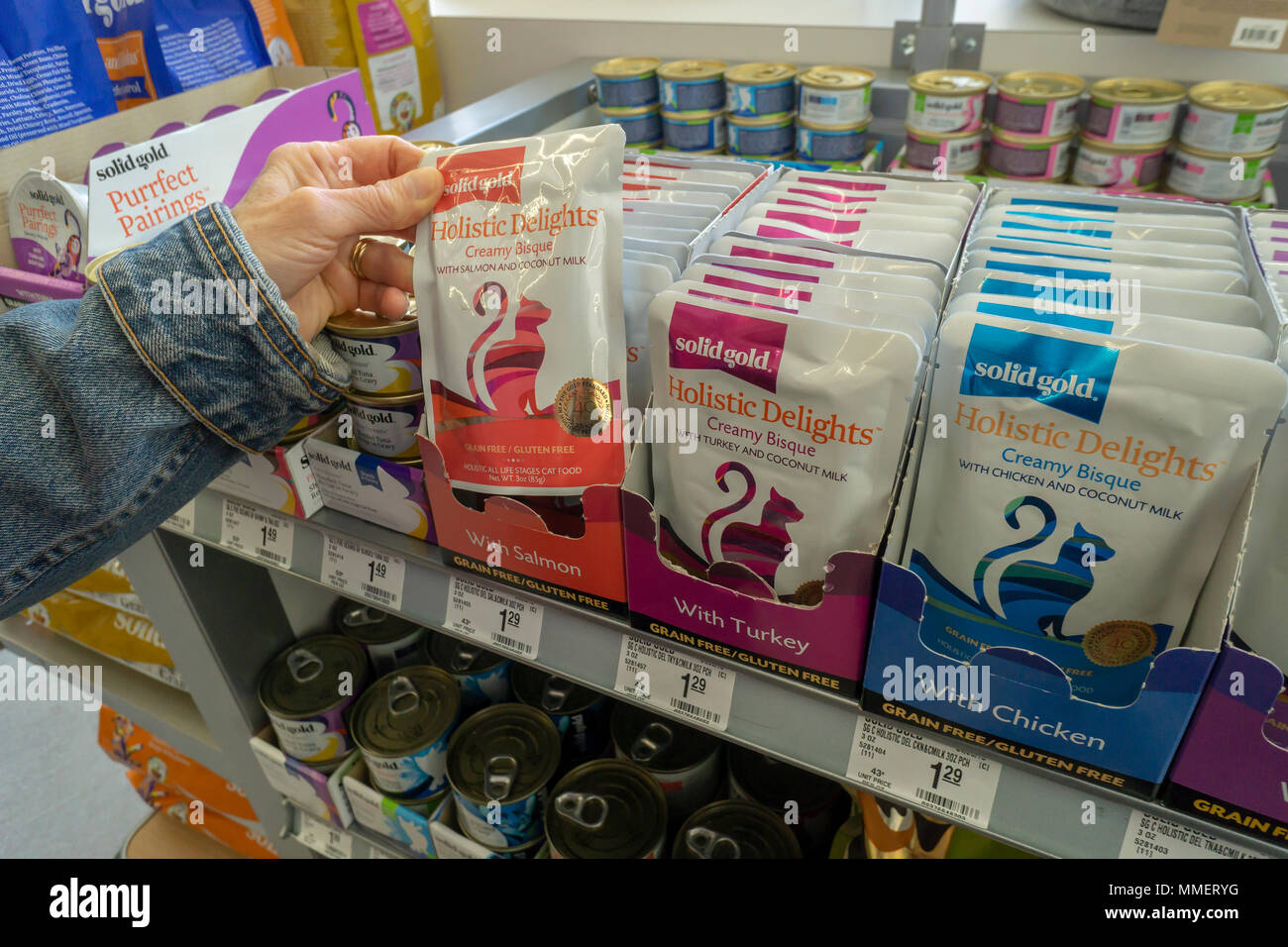 Ein Kunde wählt ein Pack von Solid Gold Marke ganzheitlich, Korn und glutenfreie Katzenfutter bei der Eröffnung eines PetSmart Store im Flatiron Viertel von New York am Samstag, 28. April 2018. PetSmart wird berichtet, um die Öffnung bis zu 60 neue Stores werden im Jahr 2018 zum Verdruß der des Einzelhändlers wertpapierinhaber sie auch Noten von PetSmart Erwerb im letzten Jahr von Chewy.com für $ 3 Milliarden. PetSmart geöffnet über 100 Stores in den letzten zwei Jahren. (© Richard B. Levine) Stockfoto