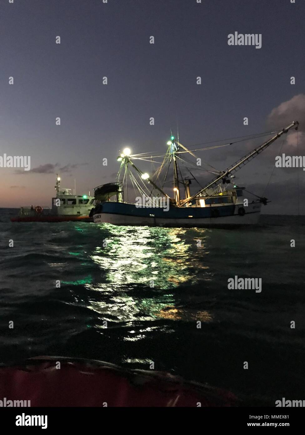 Zwei Coast Guard Station South Padre Island Antwort bootscrews Arbeit zu entwässern ein Fischereifahrzeug nehmen auf Wasser nach Rettung die vier Fischer an Bord 5 Meilen östlich von South Padre Island, Texas, Okt. 30, 2017. Nach insgesamt vier Entwässerung Pumpen, die Rate der überschwemmung konnte nicht gebremst werden, und das Schiff schließlich sank. U.S. Coast Guard Foto mit freundlicher Genehmigung Asset. Stockfoto