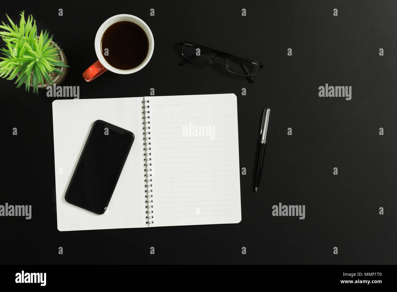 Arbeitsbereich tisch Schreibtisch mit Notebook, Smartphone, Stift, Kaffee, Brillen und Topfpflanzen. Ansicht von oben. Stockfoto