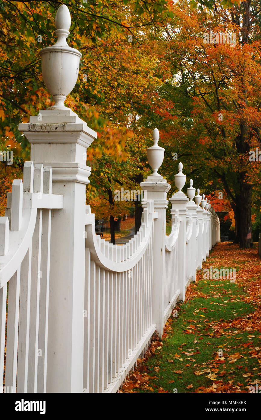 Einen weißen Lattenzaun Kontraste gegen die bunten Blätter im Herbst in Vermont. Stockfoto