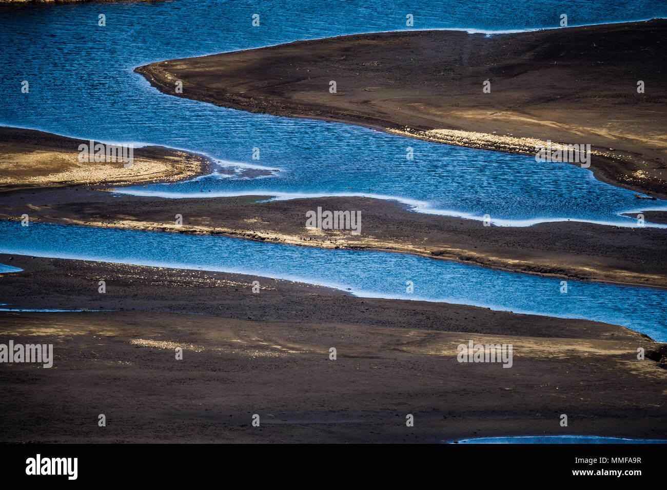 Die schlammigen Ufer eines künstlichen Damm während einer Dürre. Stockfoto
