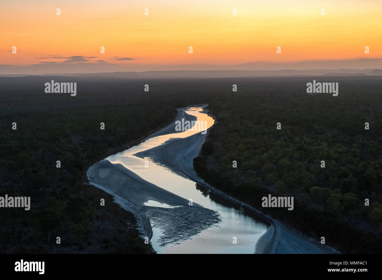 Den Sonnenuntergang Nachleuchten Reflexionen auf eine breite Tidal River fließt über ein remote Outback Cattle Station. Stockfoto