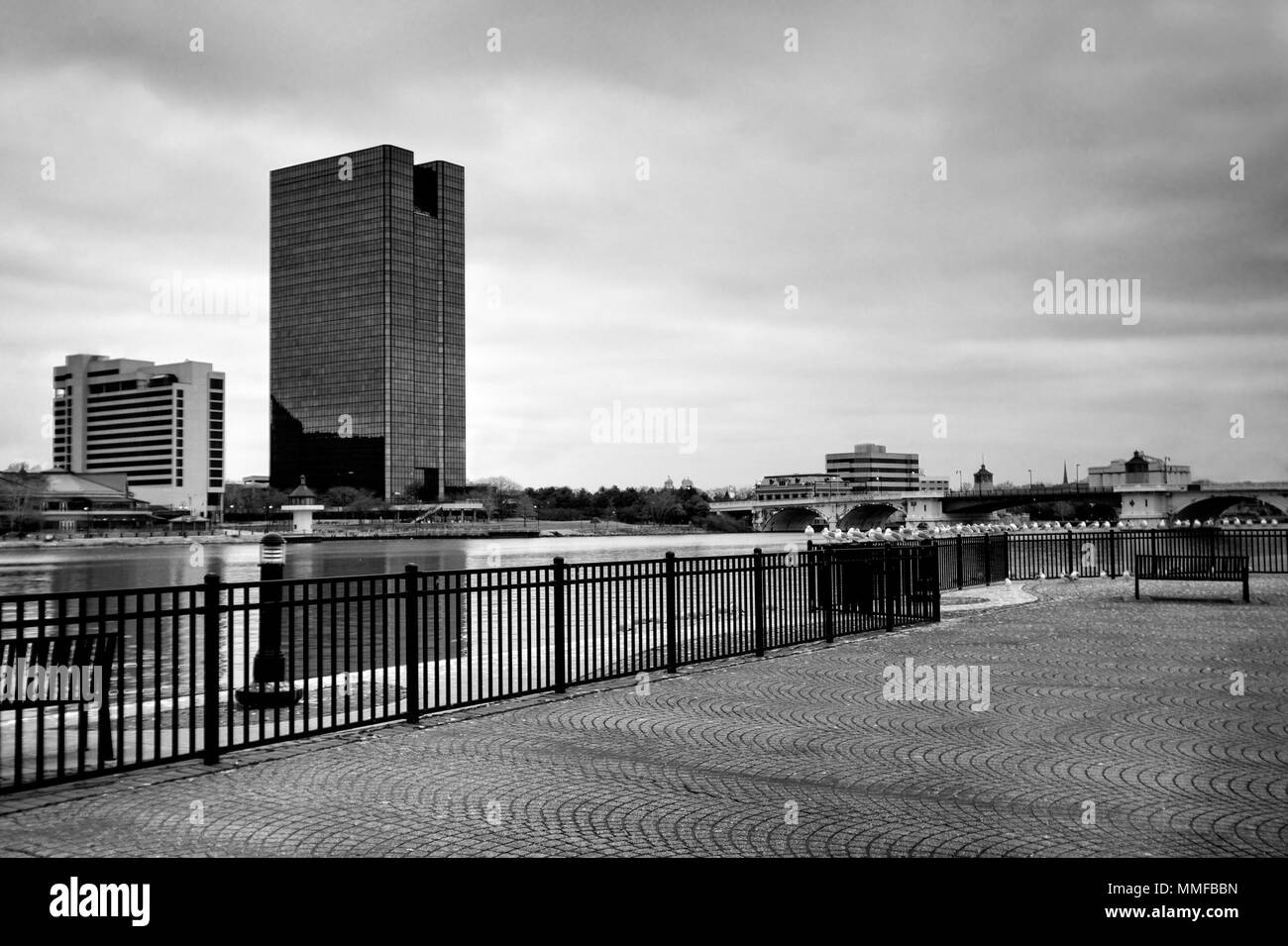 Einen Panoramablick über die Innenstadt von Toledo Ohio Skyline aus über dem Maumee River ein beliebtes Restaurant mit einem fertiger Backstein Boardwalk. Stockfoto