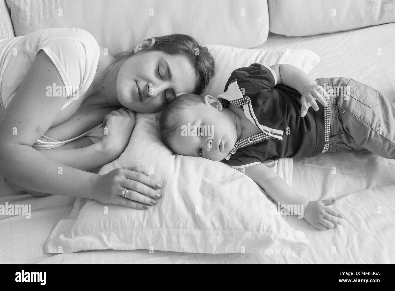 Schwarze und weiße High Point anzeigen Foto der jungen Mutter schlafen neben Ihrem baby boy im Bett lag, Stockfoto