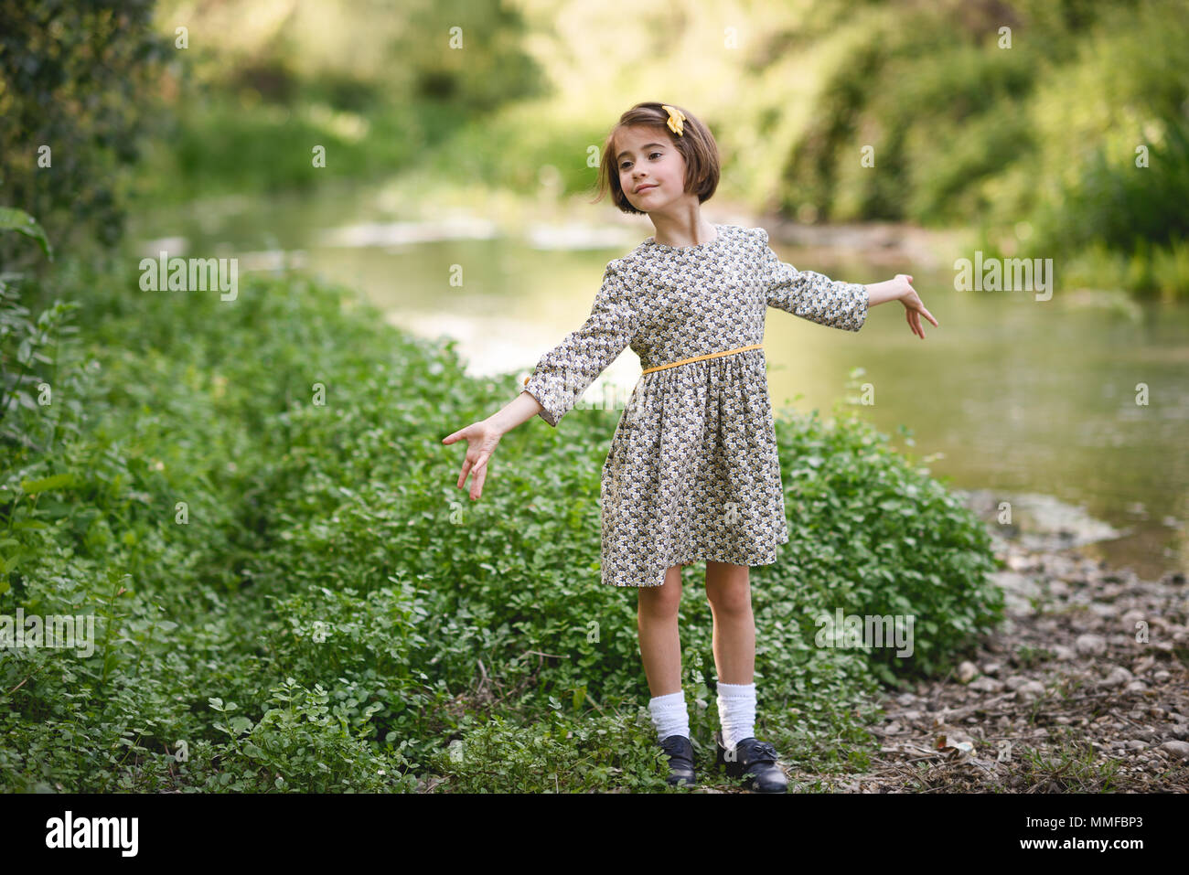 Kleine hübsche Mädchen in der Natur Strom tragen schöne Kleid Stockfoto