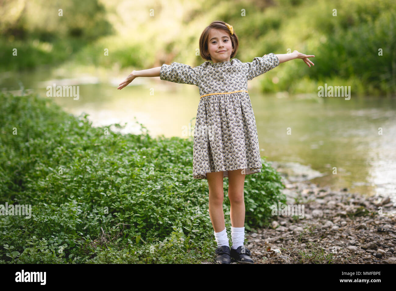 Kleine hübsche Mädchen in der Natur Strom tragen schöne Kleid Stockfoto