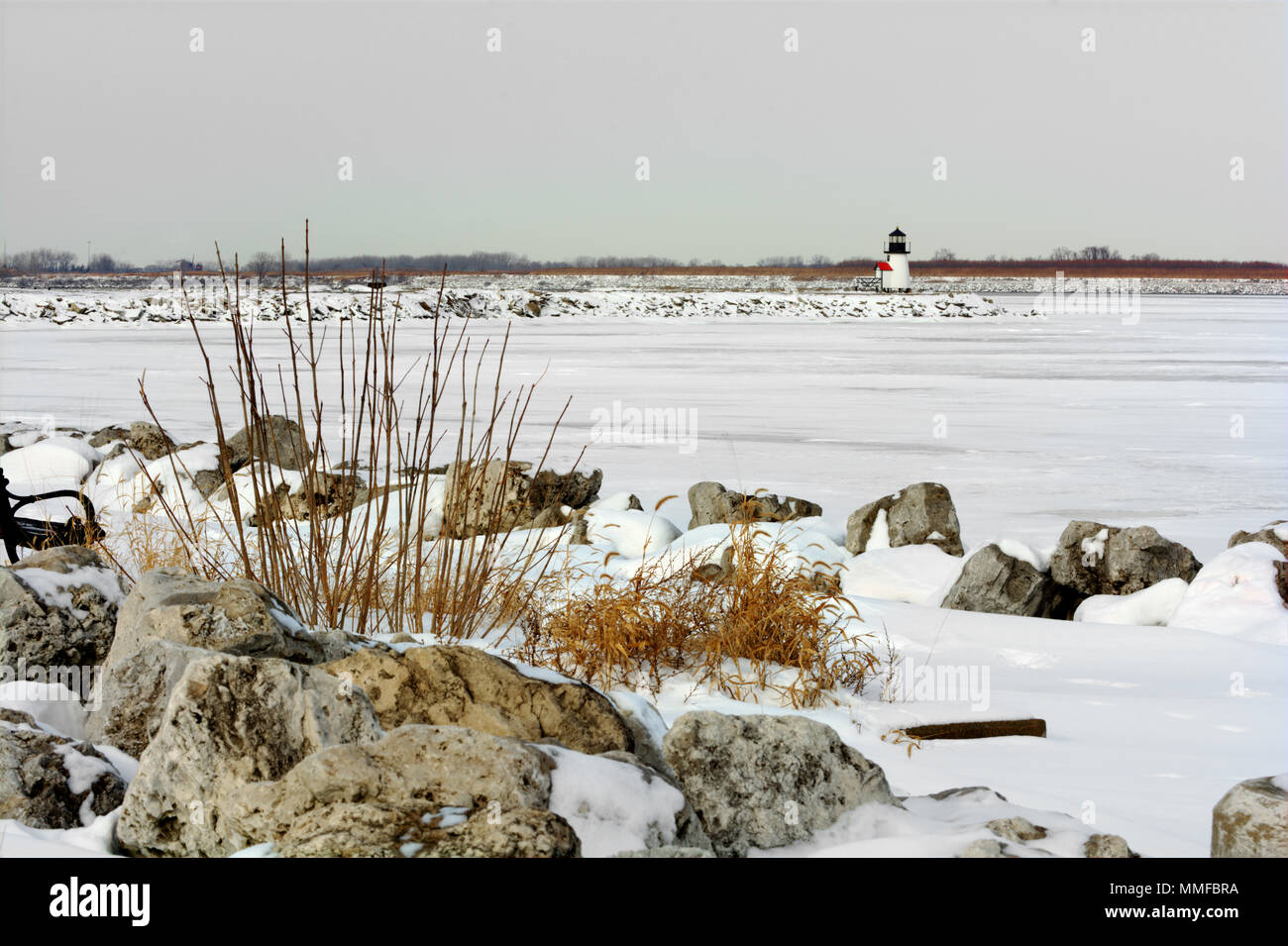 Ein kleiner Leuchtturm an der Hafeneinfahrt von Toledo Ohio im Winter. Lake Erie ist gefroren und mit Schnee in diesem Winter Szene abgedeckt. Stockfoto