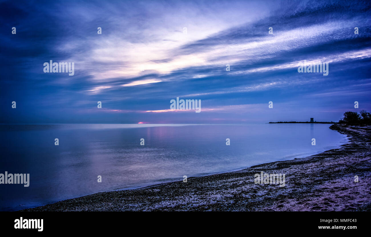 Schönen Pastelltönen Sonnenaufgang über Lake Erie von Magee Marsh im Nordwesten von Ohio. Davis-Besse Kernkraftwerk kann in der Ferne zu sehen ist. Stockfoto