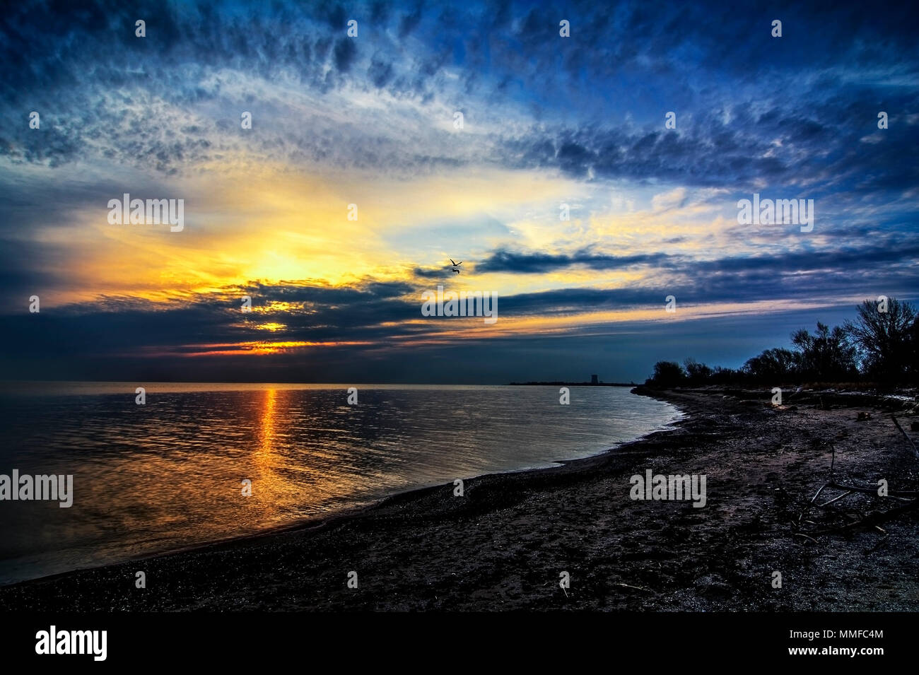 Schönen Sonnenaufgang über Lake Erie von Magee Marsh im Nordwesten von Ohio. Davis-Besse Kernkraftwerk kann in der Ferne zu sehen ist. Stockfoto
