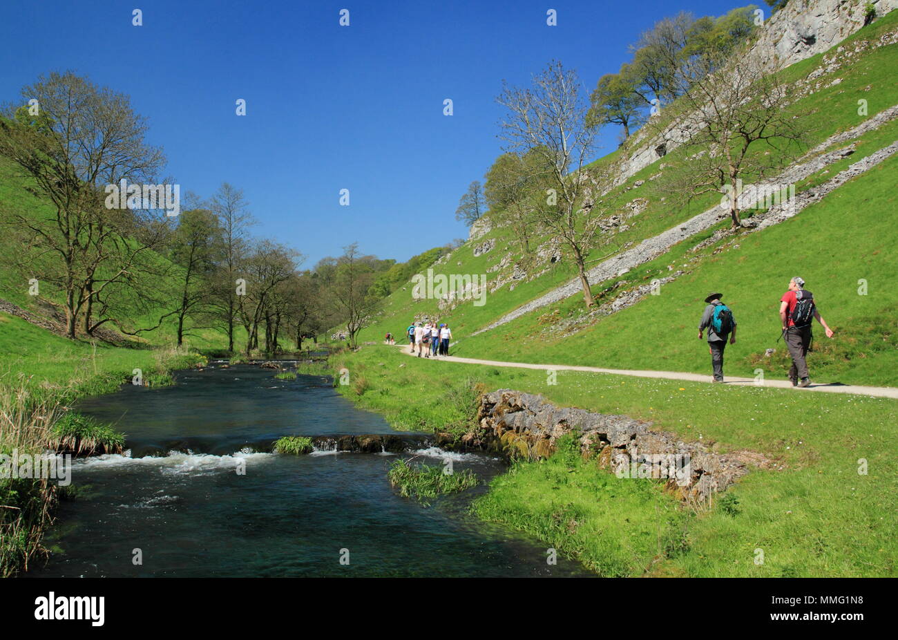 Spaziergänger auf öffentlichen Fußweg durch den Fluss Dove in Wolfscote Dale, Peak District an einem schönen Frühlingstag (Mai), Derbyshire, England, Großbritannien Stockfoto