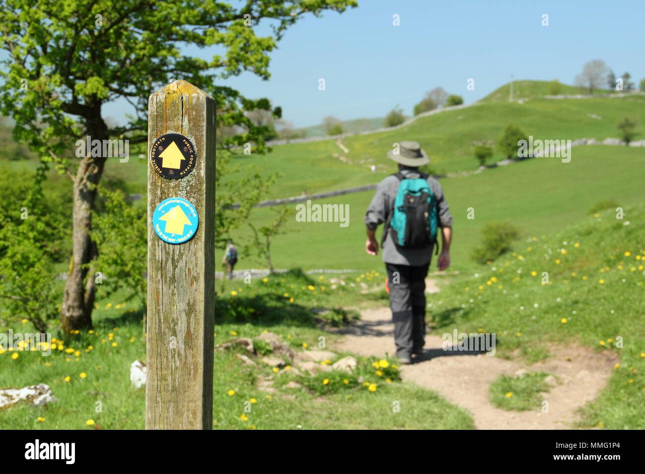 Männliche Wanderer auf Fußweg nähern Hartington Dorf von Southside in der Nähe von Pennilow, in der Nationalpark Peak District, Derbyshire, Großbritannien - mittlere Feder Stockfoto