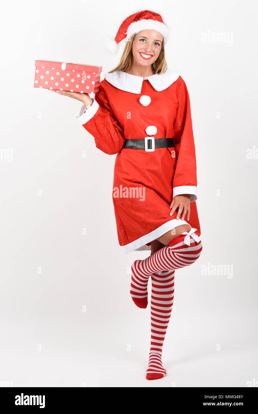 Blonde Frau in Santa Claus Kleidung lächelnd mit Geschenk in den Händen. Junge Frau mit blauen Augen das Tragen von Socken, isoliert auf weißem Stockfoto