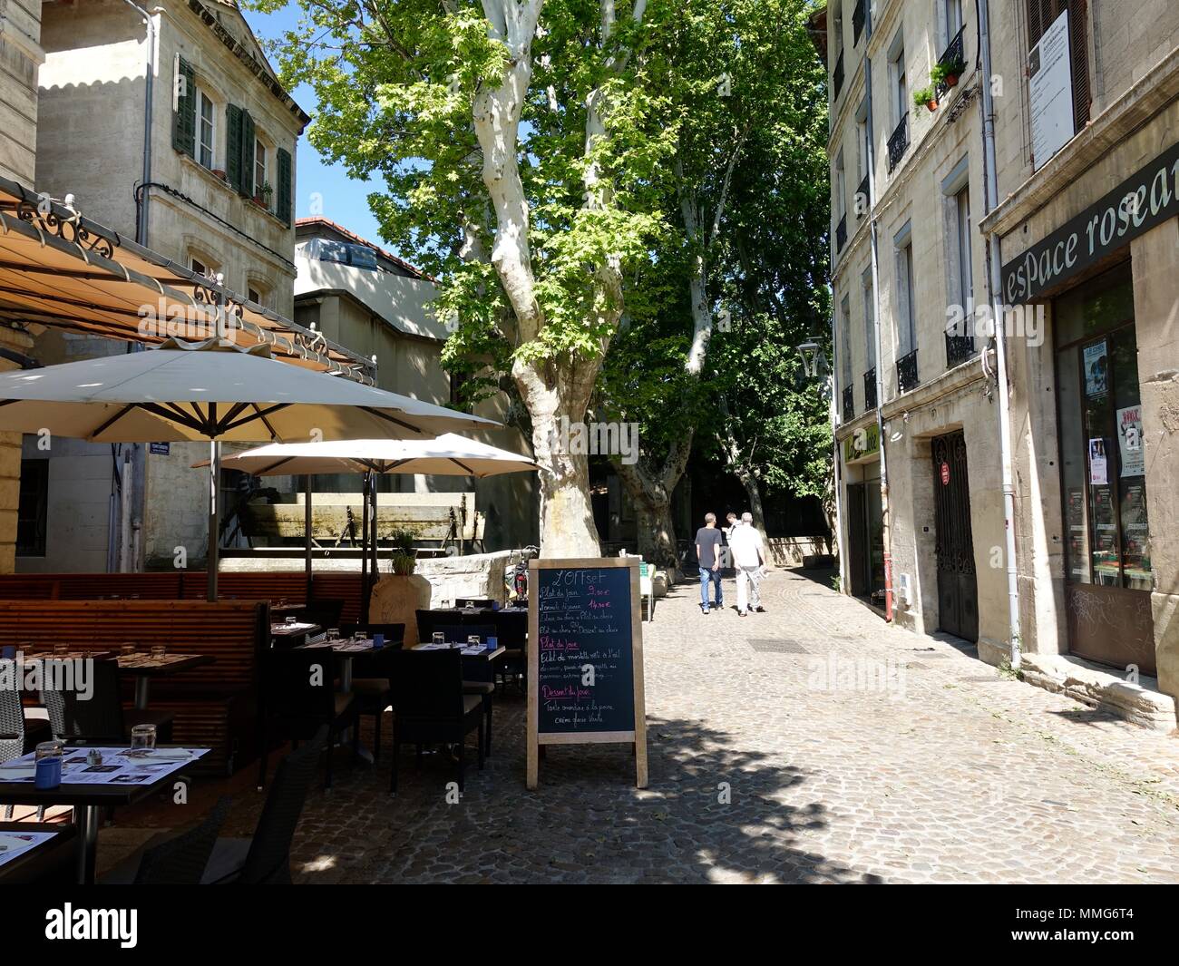 Menschen zu Fuß auf den malerischen, kopfsteingepflasterten Straße Rue des Strasse Teinturiers am Morgen an einem schönen Tag, Avignon, Frankreich Stockfoto